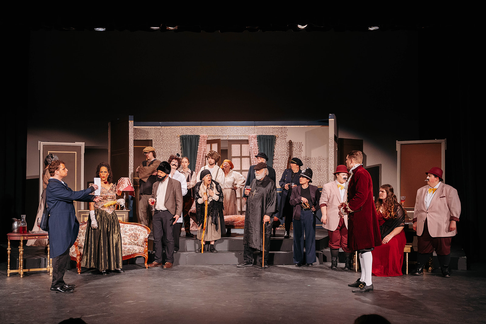 Rosetown Playhouse Full ensemble scene with the entire cast arranged across the stage in their various period costumes, holding wine glasses in what appears to be a party or celebration scene.